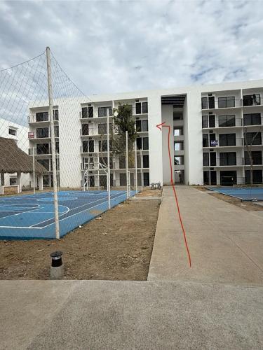 a net in front of a building with a tennis court at Departamento in Naranjo