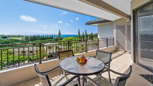 un tavolo e sedie su un balcone con un cesto di frutta di Kapalua Golf Villa 19V1 a Kapalua