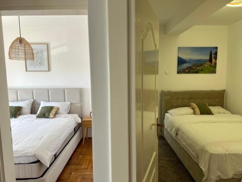 a bedroom with two beds and a mirror at Tivat Apartment in Tivat