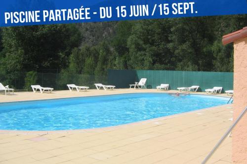 - une piscine avec des chaises et un bouquet dans l'établissement Le nid des Bains - Climatisé - Piscine partagée, à Digne-Les-Bains