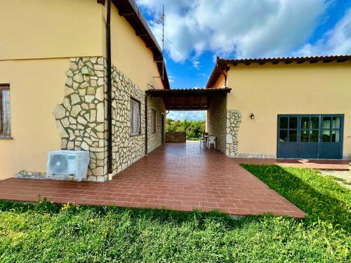 a house with a brick walkway in front of it at Villa Tuscia apartments in Tuscania