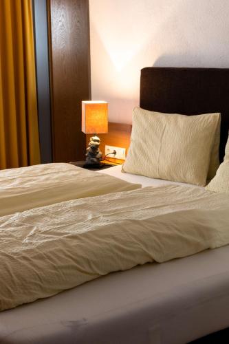 a bedroom with a large bed with a lamp on a table at Gästehaus -Pension Edelweiss in Vent