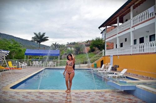 a woman in a bikini standing next to a swimming pool at Sea Natural in San Gil