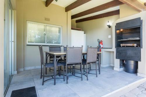 a dining room with a table and chairs at Chakas Rock Chalets 15 in Ballito