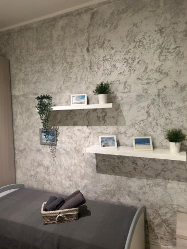 a room with shelves on a wall with a bed at CASA DI MANU e DADO in Vimodrone