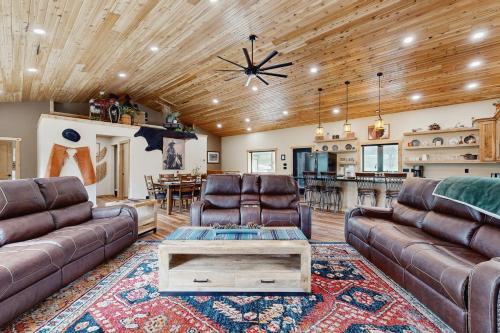 a living room with leather couches and a table at Bear Butte Hideaway in Deadwood