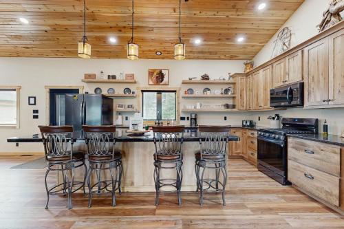 a kitchen with wooden cabinets and a counter with bar stools at Bear Butte Hideaway in Deadwood