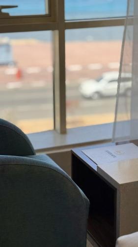 a room with a chair and a table and a window at SEAVIEW HOTEL in Umm Lujj