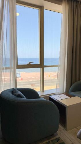 a living room with a couch and a large window at SEAVIEW HOTEL in Umm Lujj