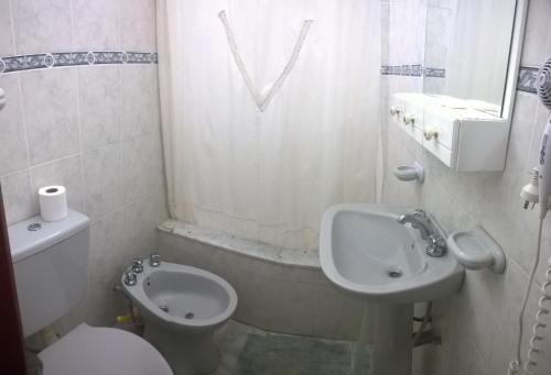 a white bathroom with a toilet and a sink at Apart Ma & Cris in Termas de Río Hondo