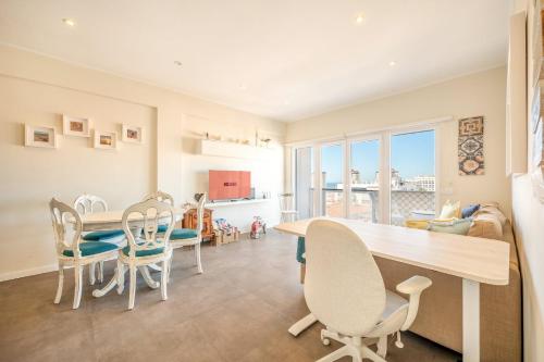 コスタ・ダ・カパリカにあるGuestReady - Seaview in Costa da Caparicaのテーブルと椅子のあるキッチンとダイニングルーム