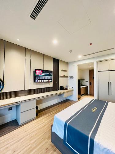 a bedroom with a bed and a desk with a tv at Flamingo Hải Tiến - IBIZA - Phòng 526 và 724 in Thanh Hóa
