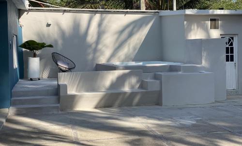 a white wall with stairs and a plant on it at Casa Punta Perula in Pérula