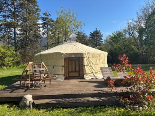 a yurt with a couple of chairs and a wooden deck at Yourte mongole in Champfromier
