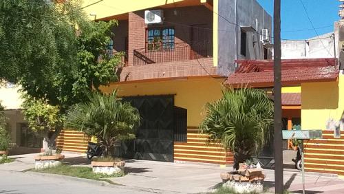 a building with stairs and palm trees in front of it at Apart Ma & Cris in Termas de Río Hondo