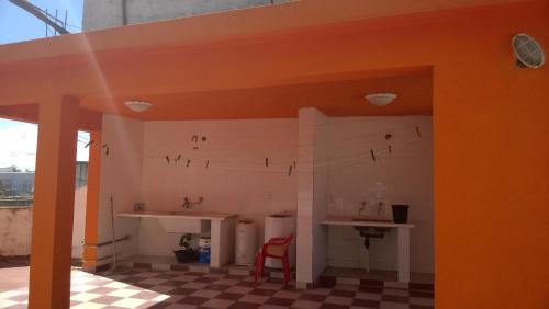 une cuisine avec un comptoir et une chaise rouge dans l'établissement Apart Ma & Cris, à Termas de Río Hondo