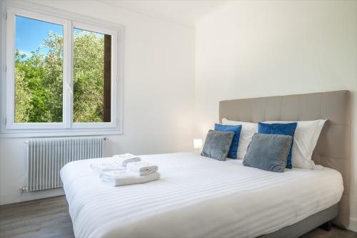 a bedroom with a large white bed with a window at Le Coq Saint-Jean - Parking - WiFi - Reposant in Gorbio