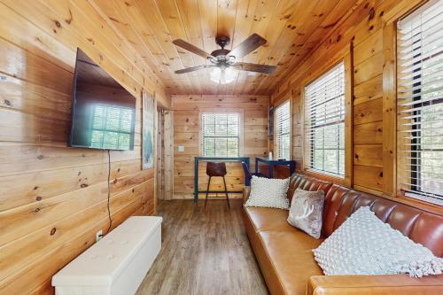 a living room with a couch and a ceiling fan at NautiPine Lodge in Sevierville