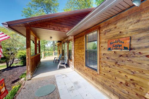 a wooden cabin with awning and a patio at NautiPine Lodge in Sevierville