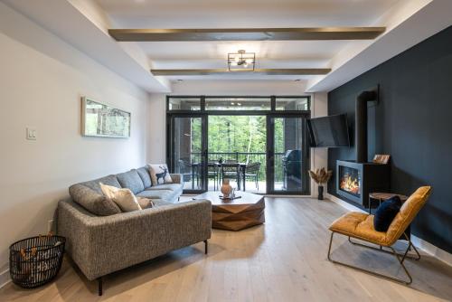 a living room with a couch and a fireplace at Tremblant Prestige - Verbier 2-104 in Mont-Tremblant