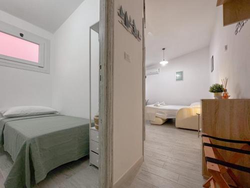 Ένα ή περισσότερα κρεβάτια σε δωμάτιο στο Stintino Center - Wi-Fi & Private Parking by Host Hero