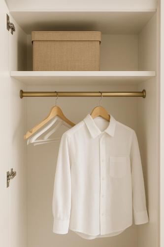 une chemise blanche sur un cintre dans un placard dans l'établissement Studio chic à 200 m du Palais des Festivals, au cœur du shopping Cannois, à Cannes