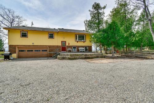a yellow house with a garage and a driveway at Breathtaking Sunsets Lake Huron Beachfront Escape in Alpena