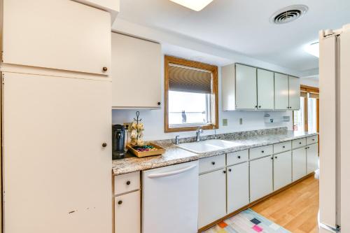 a kitchen with white cabinets and a window at Breathtaking Sunsets Lake Huron Beachfront Escape in Alpena