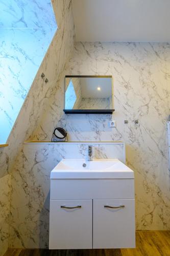 a bathroom with a white sink and a mirror at Ferienwohnung mit Sonnenbalkon & Parkplatz in Neustadt an der Weinstraße