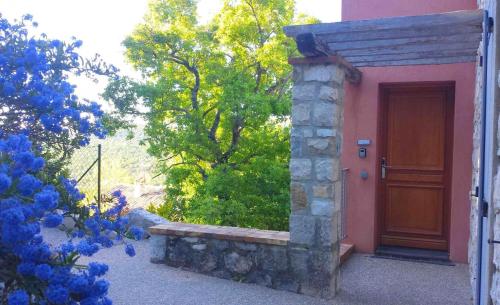 a door of a house with a bench in front of it at Le cheiron in Coursegoules