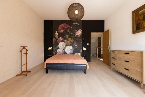 une chambre avec un lit et un tableau au mur dans l'établissement La grange au puits, à Saint-Paul-Lizonne