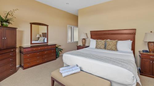 a bedroom with a large bed and a mirror at Kapalua Ridge Villa 1511 in Kapalua