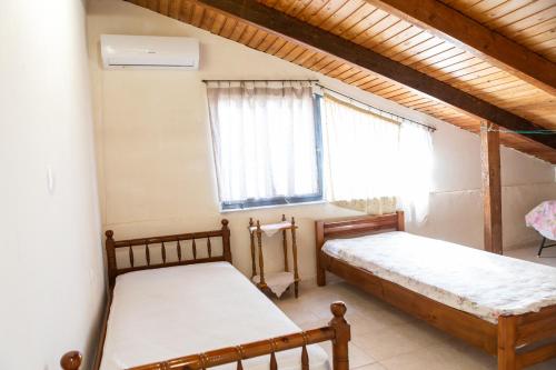 a bedroom with two beds and a window at calmia in Lefkada