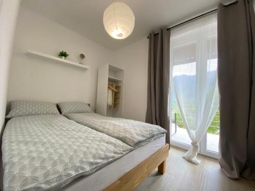 una camera da letto con un letto e una grande finestra di Apartmaji Sofija&Ana a Bovec
