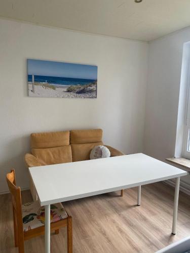 a living room with a white table and a couch at Hütti's Hütte in Oldendorf