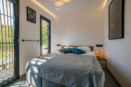 a bedroom with a bed and a large window at Water Hideout - Floating Villas in Wild Nature in Nowawieś Zbąska
