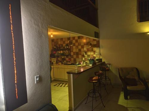 a small kitchen with a counter and stools in it at Sitio Vagalumes em Engenheiro Passos RJ próximo a Penedo in Resende