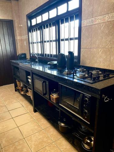 a kitchen with a counter with a stove top at Casa da Lagoa in Tramandaí