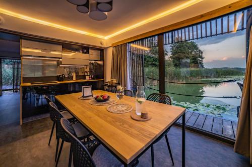 a large wooden table in a kitchen with a large window at Water Hideout - Floating Villas in Wild Nature in Nowawieś Zbąska