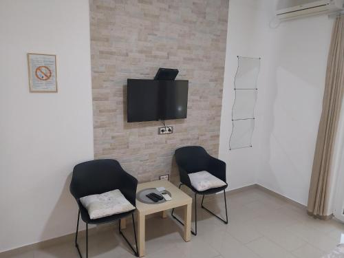 a room with two chairs and a tv on a wall at Apartments Villa Danilovic in Herceg-Novi
