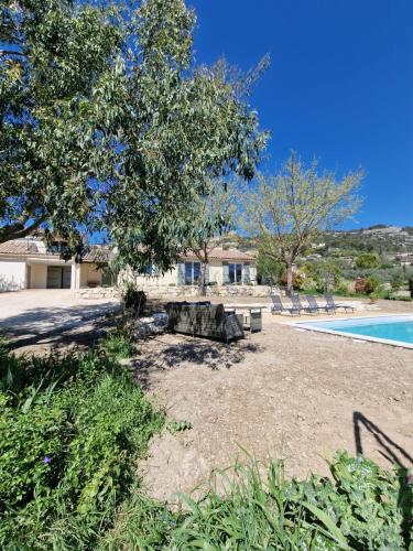 une cour avec une table de pique-nique et une piscine dans l'établissement L'Oustalet des Vignes, à Saint-Saturnin-lès-Apt