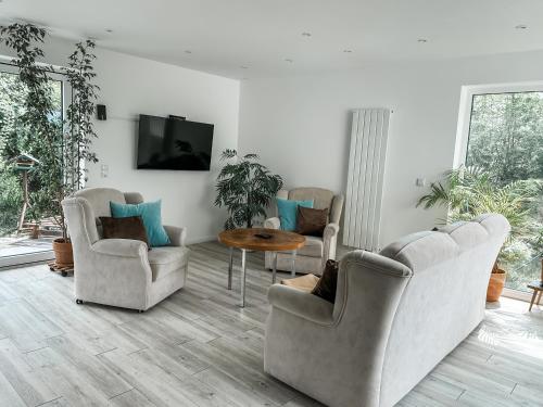 a living room with three chairs and a table at Business Apartment nähe Bonn 2 SZ in Königswinter