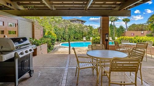 a patio with a table and chairs and a pool at Kapalua Ridge Villa 1721 in Kapalua