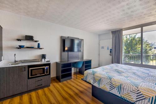 a bedroom with a bed and a sink and a television at Motel 6-Mount Jackson, VA - Shenandoah in Mount Jackson