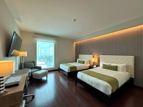 a hotel room with two beds and a window at Ramada Plaza by Wyndham Panama Punta Pacifica in Panama City