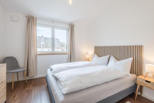 a bedroom with a white bed and a window at Pension Zum Schrammel in Altdorf bei Nuernberg
