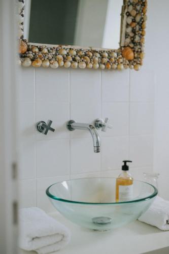 a glass sink in a bathroom with a mirror at Rivage, Chambres et Table in Saint-Pierre-Quiberon