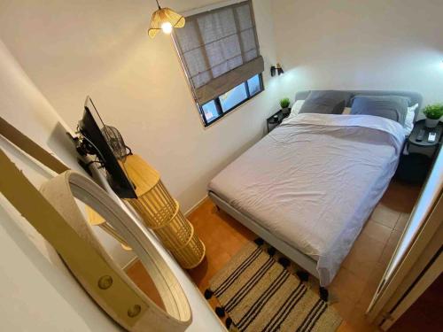 une petite chambre avec un lit et une fenêtre dans l'établissement Ô Restanque, à Six-Fours-les-Plages