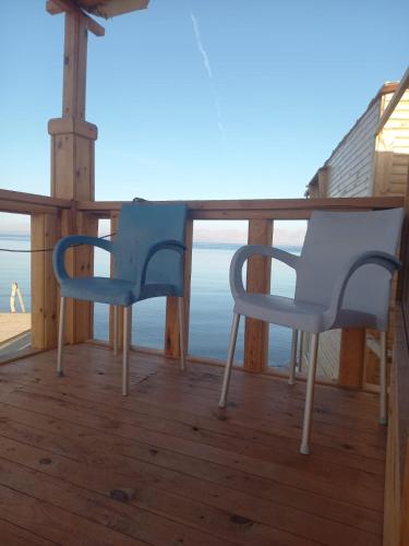 two chairs on a deck with a view of the ocean at Mountain Sinai camp in Wāsiţ
