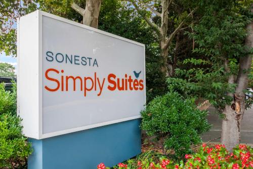 a sign for someoneagencysimply suites in front of flowers at Sonesta Simply Suites Memphis East Poplar Pike in Memphis